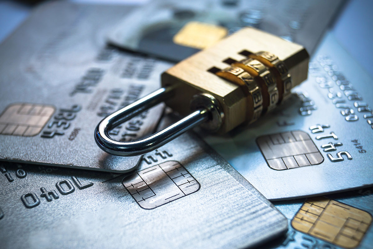 A combination padlock resting on several credit cards, symbolizing security and protection of financial information.