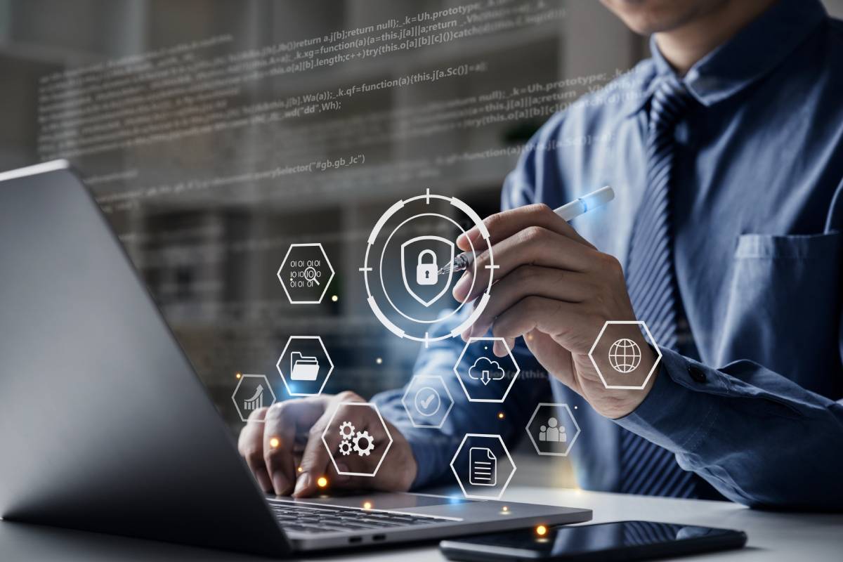 A businessman on a laptop reviewing CMMC Level 1 Compliance requirements.